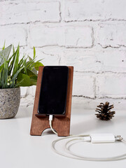smartphone in wood stand on light wooden table