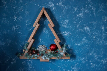 Christmas decoration in the form of a wooden Christmas tree on a blue background.