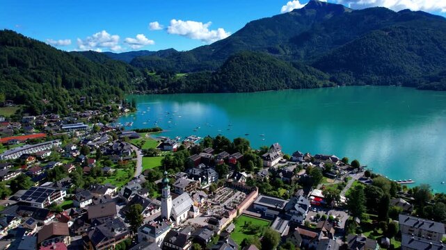 Austria tourism and most scenic places. wonderful turquoise lake Wofgangsee and beautiful village Sankt Gilgen surrounded by alps mountains Aerial drone 4k hd footage. austrian travel in Salzkammergut