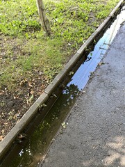 Dirty water runoff in a ditch on a private sidewalk