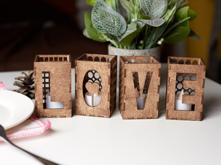 Wooden decorative candlesticks in the form of the word Love