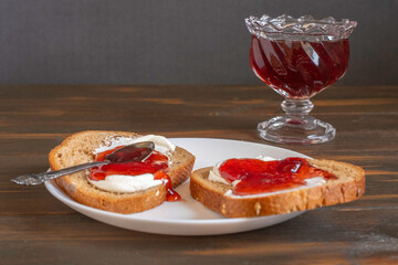 Strawberry jam and creamy cheese sandwich for simple breakfast.
