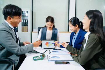 Happy businesspeople while collaborating on a new project in an office. Group of diverse businesspeople using a laptop and tablet in office.