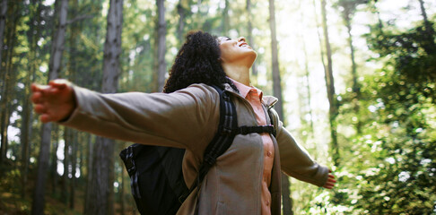 Freedom, nature and woman in forest with open arms, peaceful mood and outdoor in hiking adventure. Achievement, relax and hiker in woods with stretch, fresh air and travel on trekking journey.