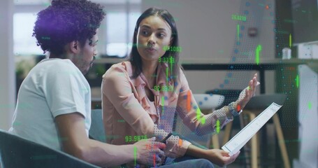 Business colleagues discussing financial data on tablet in office lounge, with candlestick overlays