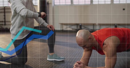 Male client holding plank in gym on mat, trainer checking smartwatch, copy space