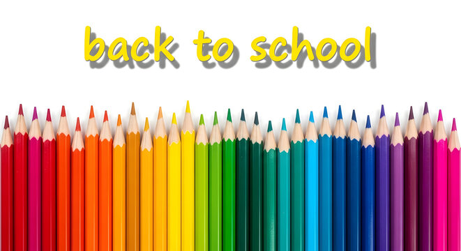 Vibrant rainbow of sharpened colored pencils arranged in a row with back to school text