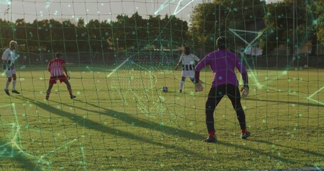 Dribbling player in white jersey guiding soccer ball near goal net on suburban field