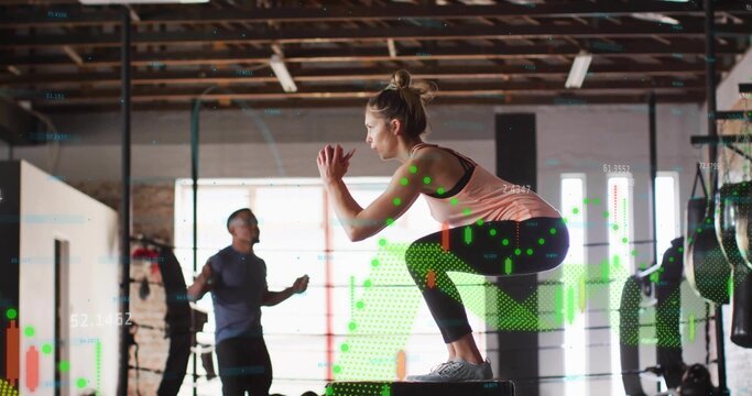 Crouching woman athlete performing squat on plyometric box in brick gym, with digital data overlay - Powered by Adobe