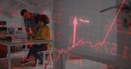 Collaborating coworkers typing and pointing at laptop in open-plan office, with stock chart overlay