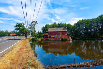 House on the side of the road and beside the fish pond