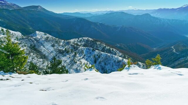Amazing aerial mountainscape, snow covered slopes, bright sunny winter day