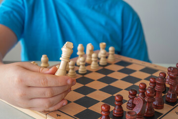 Chess piece in a child's hand. Playing chess for children.