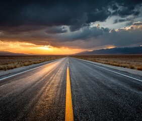 A straight, paved highway stretches into the horizon, bathed in golden sunset light beneath a dramatic sky full of ominous, dark clouds