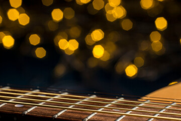 the guitar is acoustic. gold strings   on a blurred background, close-up.