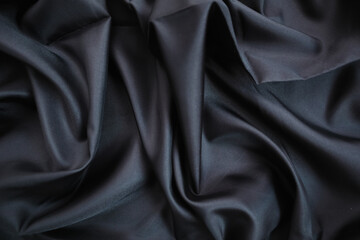 Dark Fabric with Elegant Folds. Abstract background of black silk fabric with soft, wavy folds.
