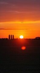 Fototapeta premium Sunset Sky: A breathtaking view of the setting sun, casting an array of vibrant colors across the sky, illuminating the tranquil landscape with its golden glow.