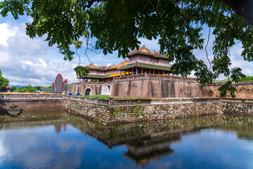 A grand, ancient citadel building with traditional architecture and a stone fortress is reflected...