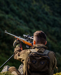 Hunting period. Hunter is aiming. The man is on the hunt. Hunter with shotgun gun on hunt. Deer...