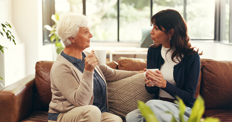 Bonding, elderly mother and mature daughter in home with tea, story time and catch up in conversation. Smile, communication and family in house with warm drinks, reunion and gossip in shared moment.