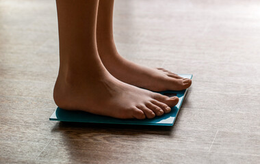 Male bare feet standing on a scales. Person standing on scale measuring weight. Health, fitness, weight, wellness. Barefoot female standing on digital weight, body fat scales with display showing