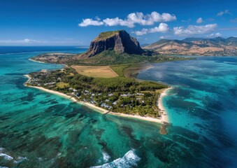 A stunning aerial view of a mountainous island with turquoise waters meeting a sandy shore under a sunny sky