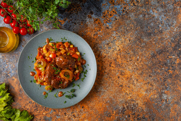 Ossobuco served with stewed vegetables.