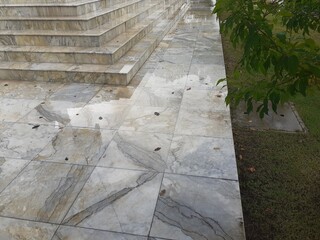 Marble pavement in a wet garden on a rainy day