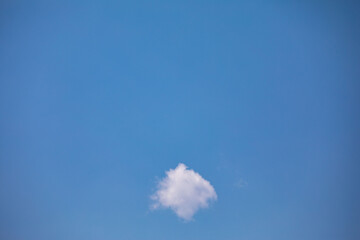 Rare scene with small white cloud isolated on blue sky background, free space for text