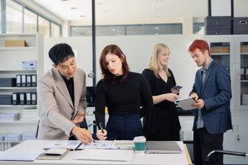 Financial analysts work overtime analyzing data on tablets, laptops, and graphs. Collaboration, teamwork, and planning.