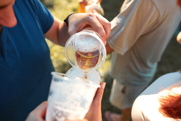 People holding beer cups and enjoying summertime outdoors.