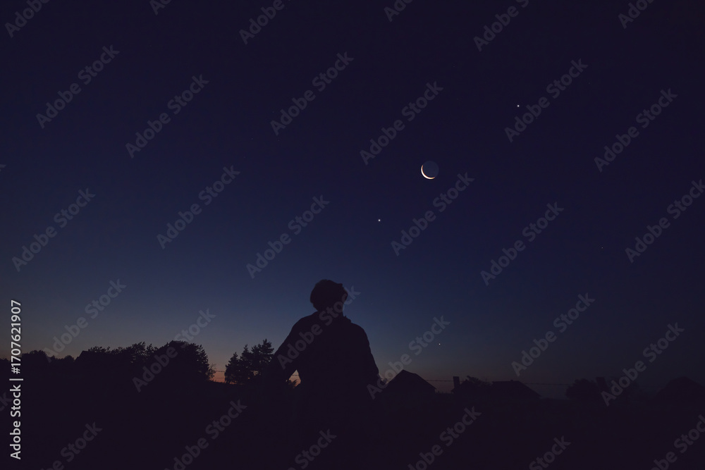 Canvas Prints silhouette of a man observing moon, milky way stars, planets and other celestial objects from a dark