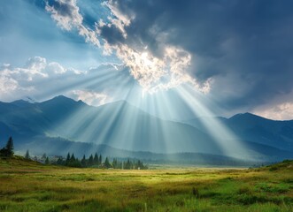 A sunlit landscape showing rays piercing dramatic clouds above rolling hills and a field dotted with trees, casting an ethereal glow