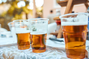 Beer glasses on a picnic table in the backyard.