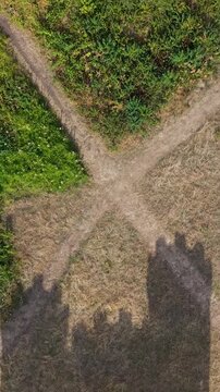 Vertical aerial top-down drone shot above grass, showing shadows of Blaise Castle&rsquo;s turrets. As the drone pulls back, the historic castle emerges from the shadow.