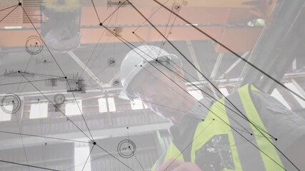 Factory tech under crane operating touchscreen showing network overlay for load monitoring - Powered by Adobe
