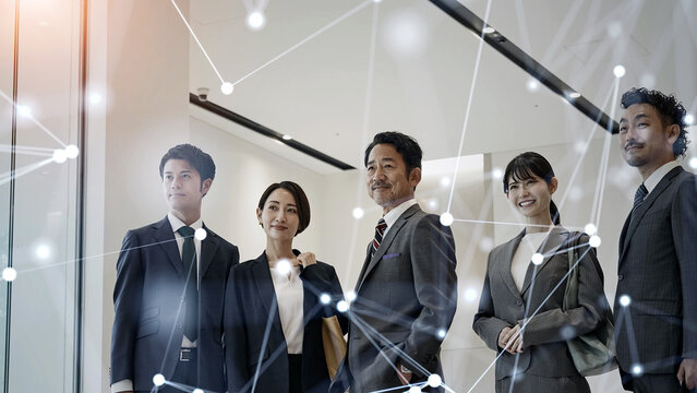 オフィスに立つビジネスパーソンのグループとネットワークイメージ