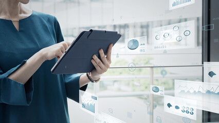 Image of a woman using a tablet and business documents