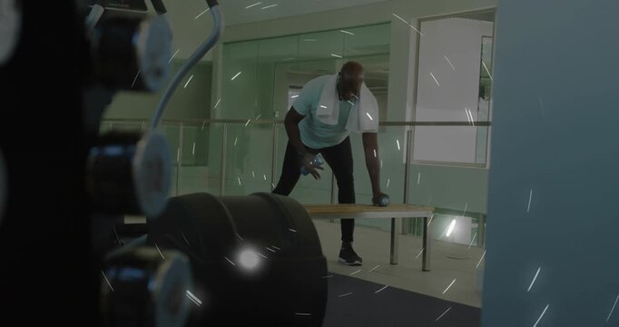 Man leaning forward grabbing dumbbells, performing alternating rowing for health with moving bars