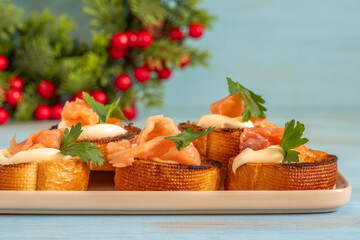Sandwiches with smoked salmon, creamy cheese for Christmas, New, Year on blue wooden background.
