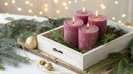 Four lit advent candles in a wooden box with evergreen branches and bokeh lights