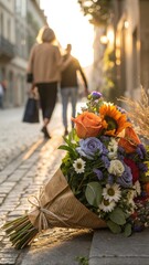 Vibrant bouquet of flowers on cobblestone street with blurred figures