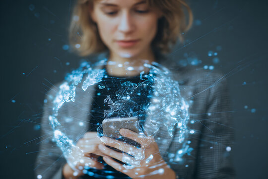 Woman interacting with a glowing digital globe on her phone showcasing global technology trends - Powered by Adobe
