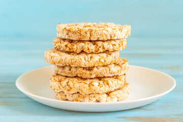 Rice cake on ceramic plate over blue wooden background.