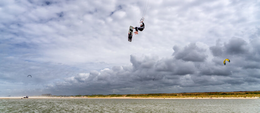 Kitesurfer Mid-Flight under Cloudy Skies at the Zandmotor Beach near The Hague