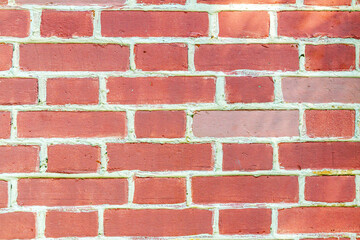Obraz premium Red brick wall with cement joints and textured masonry. Rough surface for construction, architecture, design and urban decor.