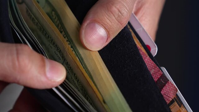 A wealthy and successful man with a large sum of money in his wallet stands at the checkout counter to pay for goods.
The man is shopping and spending money.
Savings and finances