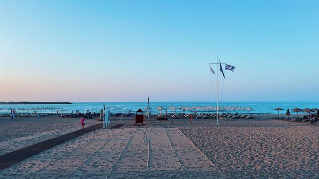 Greece, Rethimno, 05.09.2025: Early morning view of sandy beach with umbrellas
