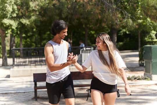 Young couple shaking hands after exercising in park