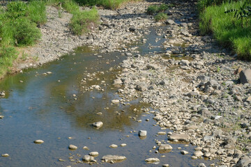 Close up of a mountain river that is starting to dry up in the dry season. Ecological and environmental concept. For graphic design, 3D rendering and banner backgrounds